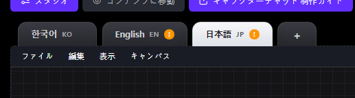 言語タブKO・EN・JP。ENとJPのタブにオレンジの感嘆符バッジが付き、それらのキャンバスがコンパイルを必要としていることを示す